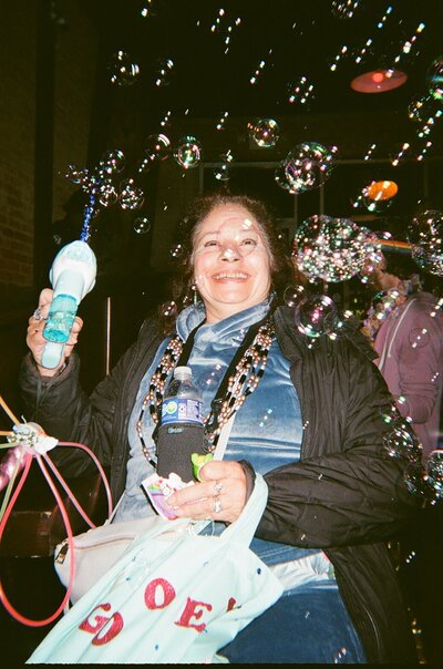 woman smiling holding bubble gun