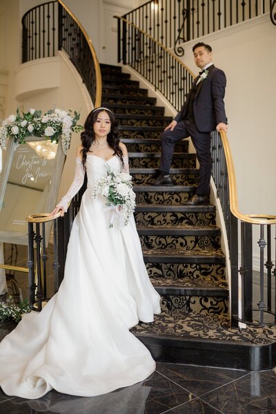 Bride and groom posing on elegant venue staircase