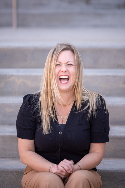 Attorney Erin K. Urquhart of McDow & Urquhart LLC sitting outside the Rock Hill, SC courthouse, laughing in a professional portrait.