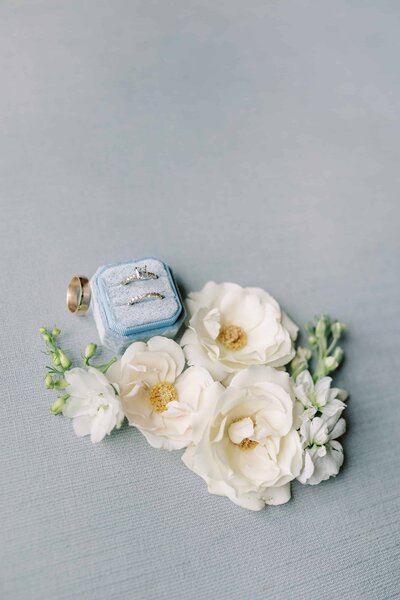 Close up photo of wedding rings with flowers