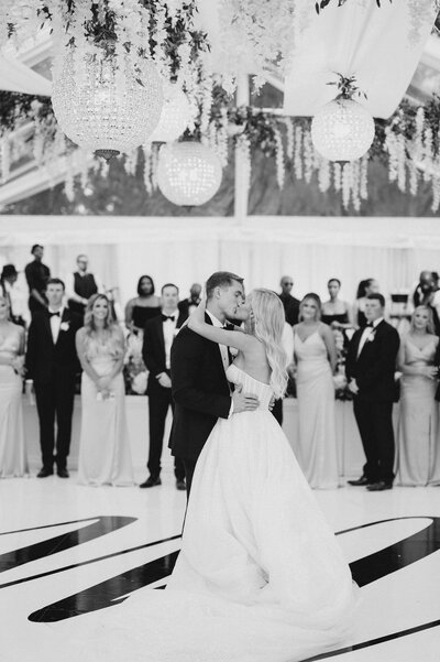 groom kissing bride's temple while bride's eyes are closed and smiling'