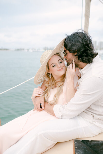 couple snuggling on a boat after their engagement miami florida