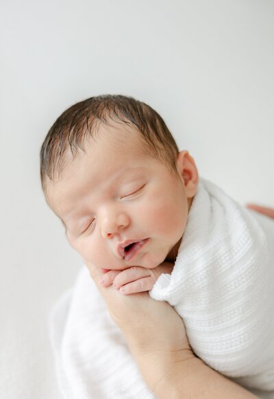 Close up of newborn in mom's hands