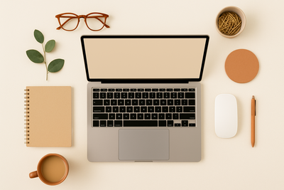 A light, cream-colored flat lay featuring a laptop, camera, and minimal desk accessories, styled to reflect a creative workspace for building websites with the Showit platform.