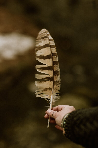 holding an owl feather 