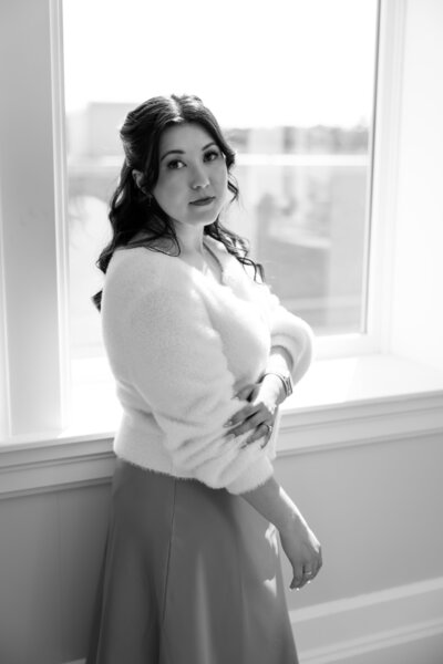 Shanté Gorman, founder of Sugarpunch Marketing®, an Instagram agency for service-based businesses, standing by a window and gazing at camera..