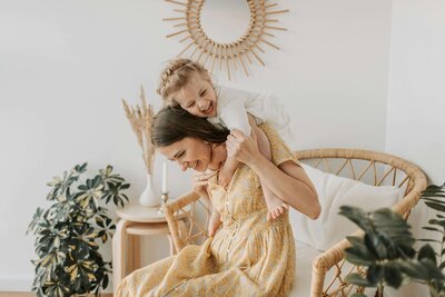 Young girl playing on her mothers back