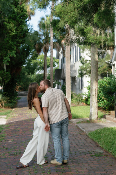 Couple kissing while holding hands taken by engagement photography florida