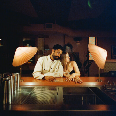cinematic 120 film photo of multiracial couple inside Meo Chinatown restaurant in Vancouver