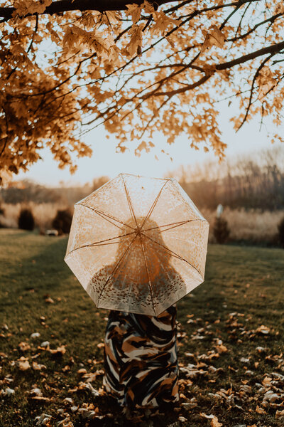 Autumn-inspired outdoor scene with transparent umbrella, evoking natural beauty and seasonal self-care at Haven Beauty Collective