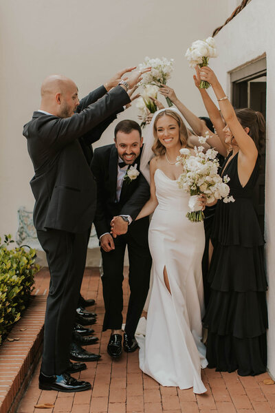 Happy couple cheering with friends after being married in San Diego