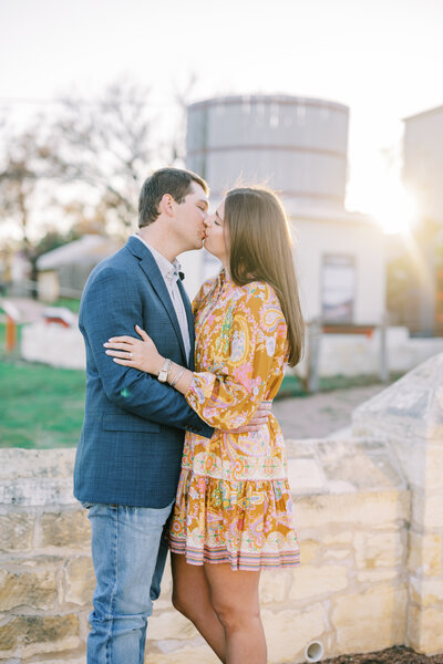 Couple kissing in front of a sunset