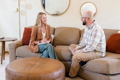 Amy sitting on the couch having a conversation with one of her clients