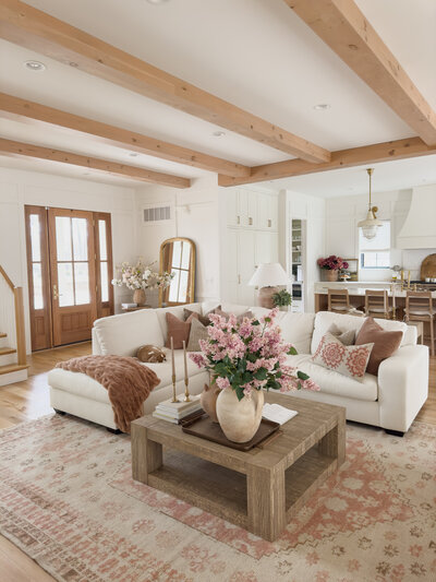 While spacious, the living room at Woodlawn House maintains a cozy vibe with a plush sectional and stained wood beams