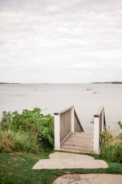  A wooden staircase leading down through greenery to the shoreline, offering serene views of Pleasant Bay at Wequassett Resort on Cape Cod.