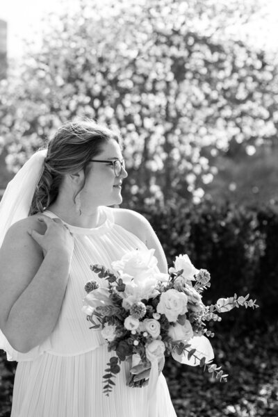 Bride holding up a bouquet of flowers during a beach elopement in Michigan.