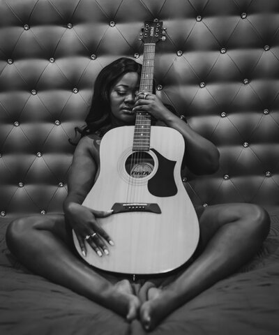Boudoir Portrait of woman with guitar covering body