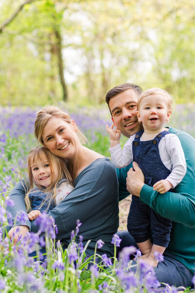 Family sit together among the bluebells