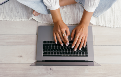 Woman's hands typing on laptop