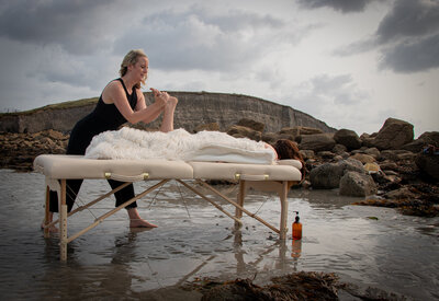 Massage therapist gives a foot massage as part of a full body routine in Galway