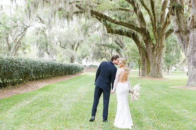 photo of bride + groom kissing at ford field and river club wedding in savannah