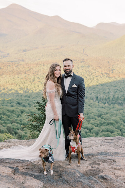 Bride and Groom posing on top of a mountain with their dogs after a sunrise hike in Lake Placid, NY.