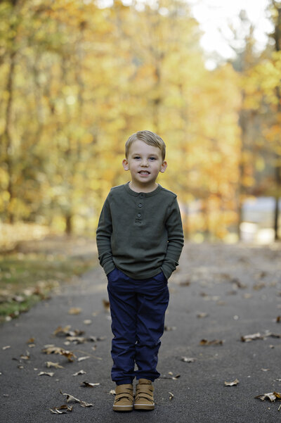 Little boy with hands in his pocket smiles during his family photos at the Gwinnett Civic Center