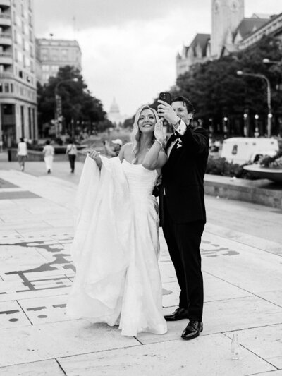 Bride and groom pause to take a selfie in between their DC wedding photography session.
