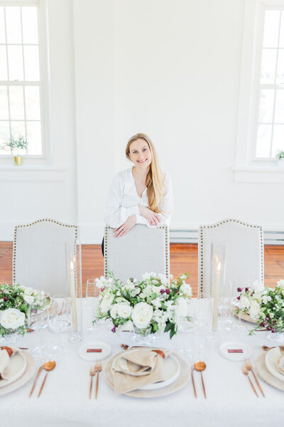 Washington DC Wedding Planner - Blue Sapphire Events poses with a white tablescape with tall candles, gold flatware, and neutral color lines.