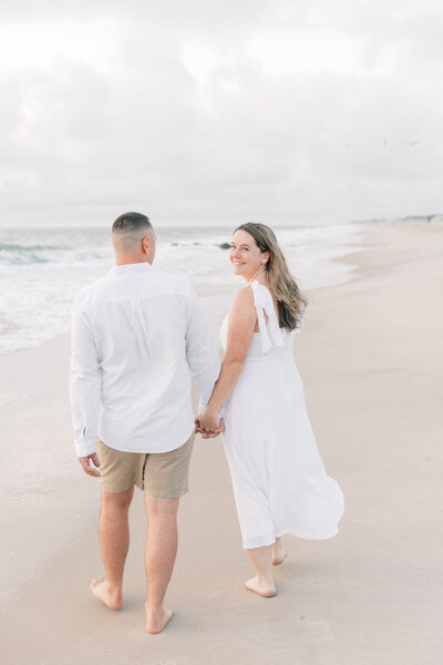 Couple walking on the beach for a sunrise engagement session