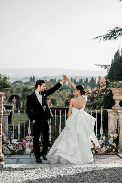 Bride and groom dancing on the terrace at Villa Catignano in Tuscany with romantic floral ceremony decor and panoramic views of the Italian countryside