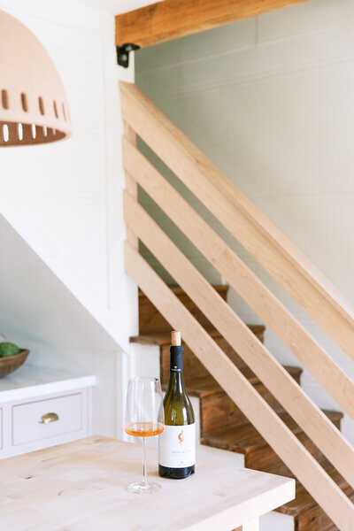 Bottle of wine beside brown stairs