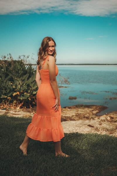 high school senior girl with jean shorts and white top in front of painted mural in winter garden shot by orlando senior photographer Melissa Vinsik