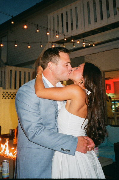 Film flash photograph of a couple who is kissing at their nighttime rehearsal dinner in Sea Isle City, NJ.