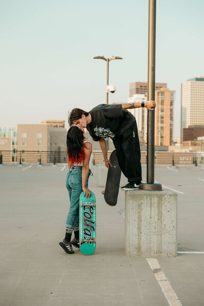 Skater couple kissing on top of rooftop garage skateboard edgy