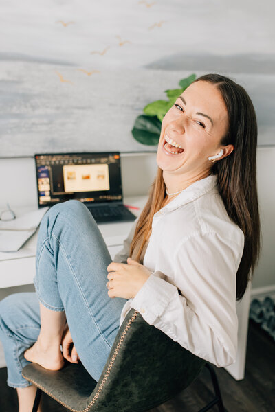 Headshot of Emily, founder of Boss & Buddha, smiling at camera with head tilted to left