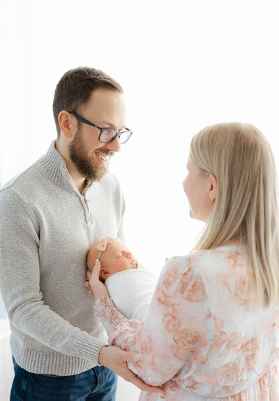 newborn baby being held by mom and dad during boston newborn photography session