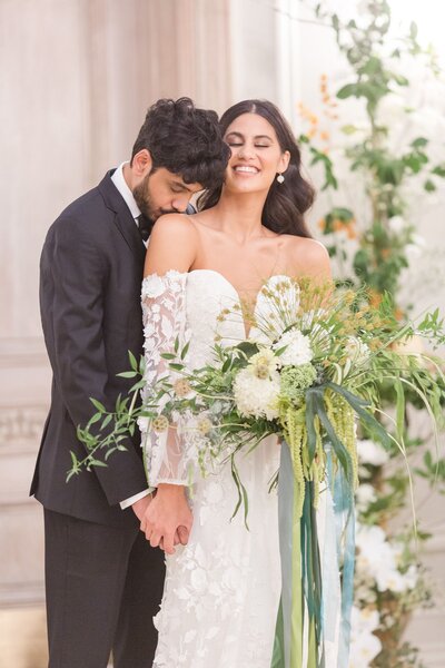 Groom kissing bride's shoulder