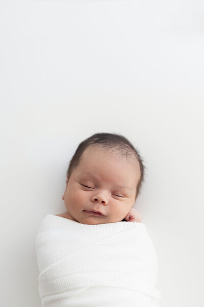 Wrapped newborn peacefully resting, captured in timeless newborn photography by Little Palm Photography in Marin County.