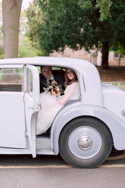 lincolnshire wedding bride and groom in the vintage classic wedding car looking towards camera and smiling