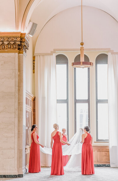 bridesmaids holding bride's veil