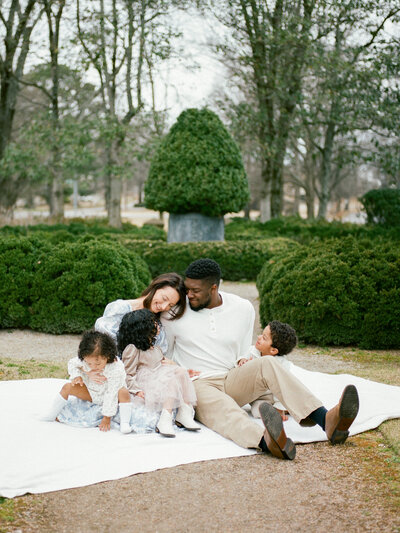 family sits on blanket at lifestyle family photo session in decatur alabama