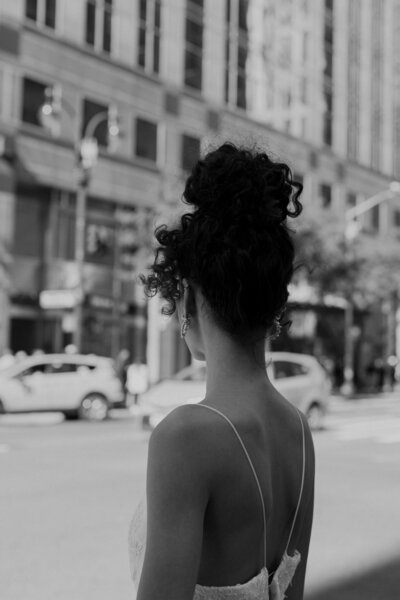 Stunning bride looks away at NYC street in her wedding gown