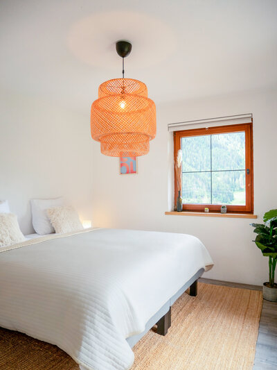 Gezellig ingerichte tweepersoonskamer met houten interieur en comfortabel bed in Haus Arlberg.
