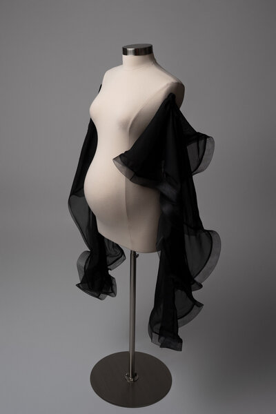 Pregnant woman wearing a statement pearl shoulder piece in a fine art maternity photo