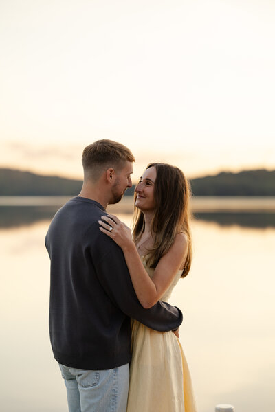 Bride and groom smile at each other with their eyes closed while their noses touch