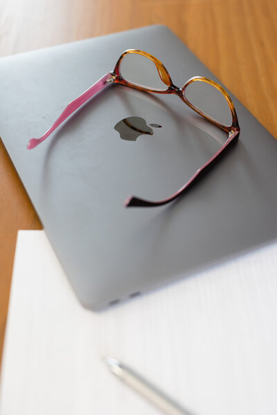 Closed lap top with a pair of glasses sitting on top