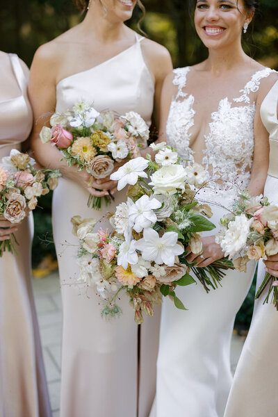 Elegant fall bridal bouquet and bridesmaid’s bouquets in Raleigh, NC with dahlias, clematis, roses, hydrangeas, and fall branches in colors of mauve, copper, cream, dusty pink, and green. Design by Rosemary and Finch in Nashville, TN.