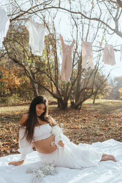 pregnant woman sitting on blanket during maternity photos captured by NYC maternity photographer Elsie Goodman