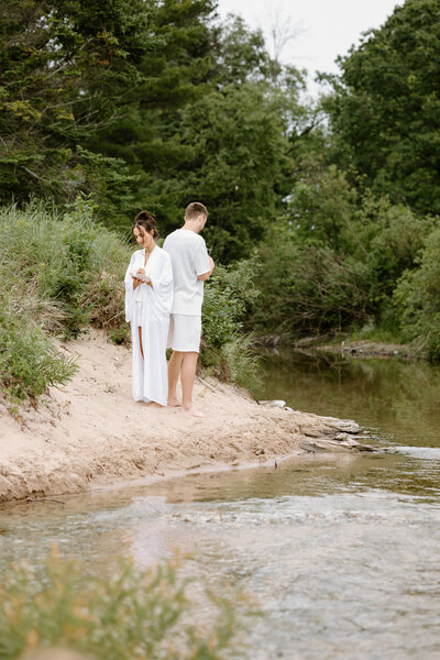Bride holding up a bouquet of flowers during a beach elopement in Michigan.